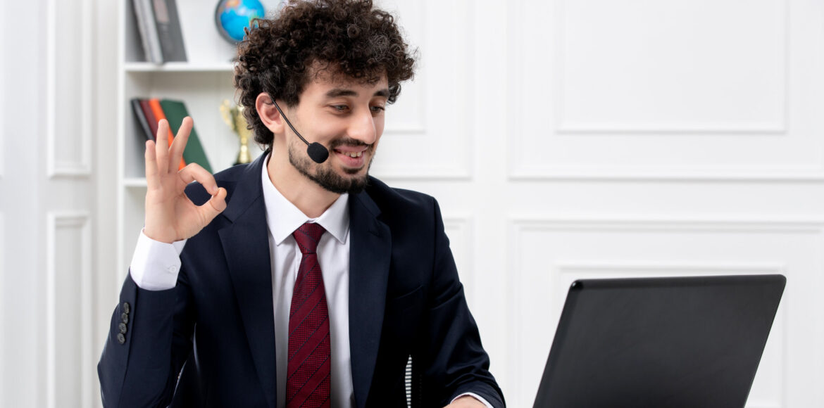 customer-service-handsome-young-guy-office-suit-with-laptop-headset-showing-ok-gesture