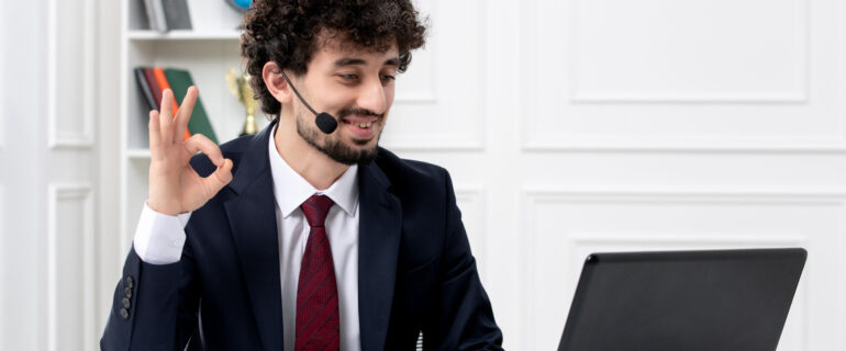 customer-service-handsome-young-guy-office-suit-with-laptop-headset-showing-ok-gesture